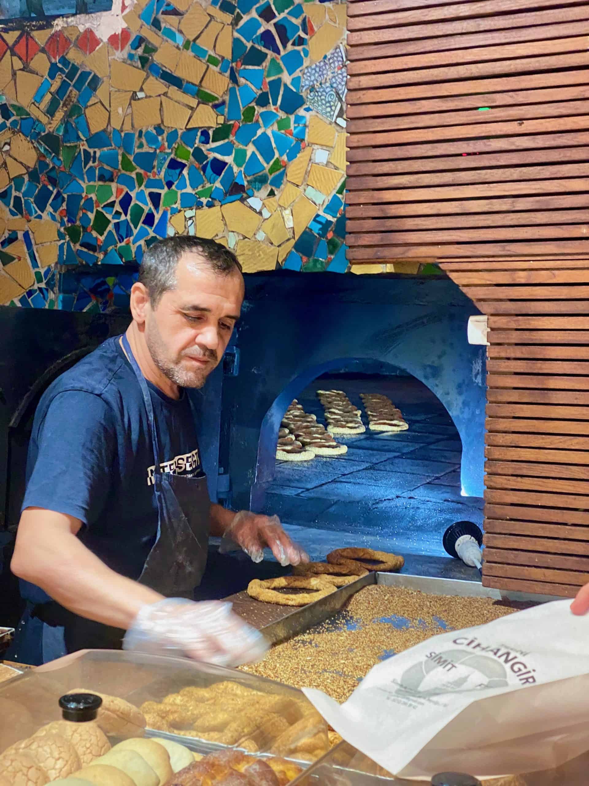 Baker taking simit, a traditional Istanbul street food out of the oven